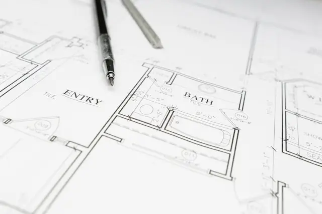 Architectural blueprints showing floor plans with labeled rooms including Entry and Bath, alongside a black pen and ruler on white paper.